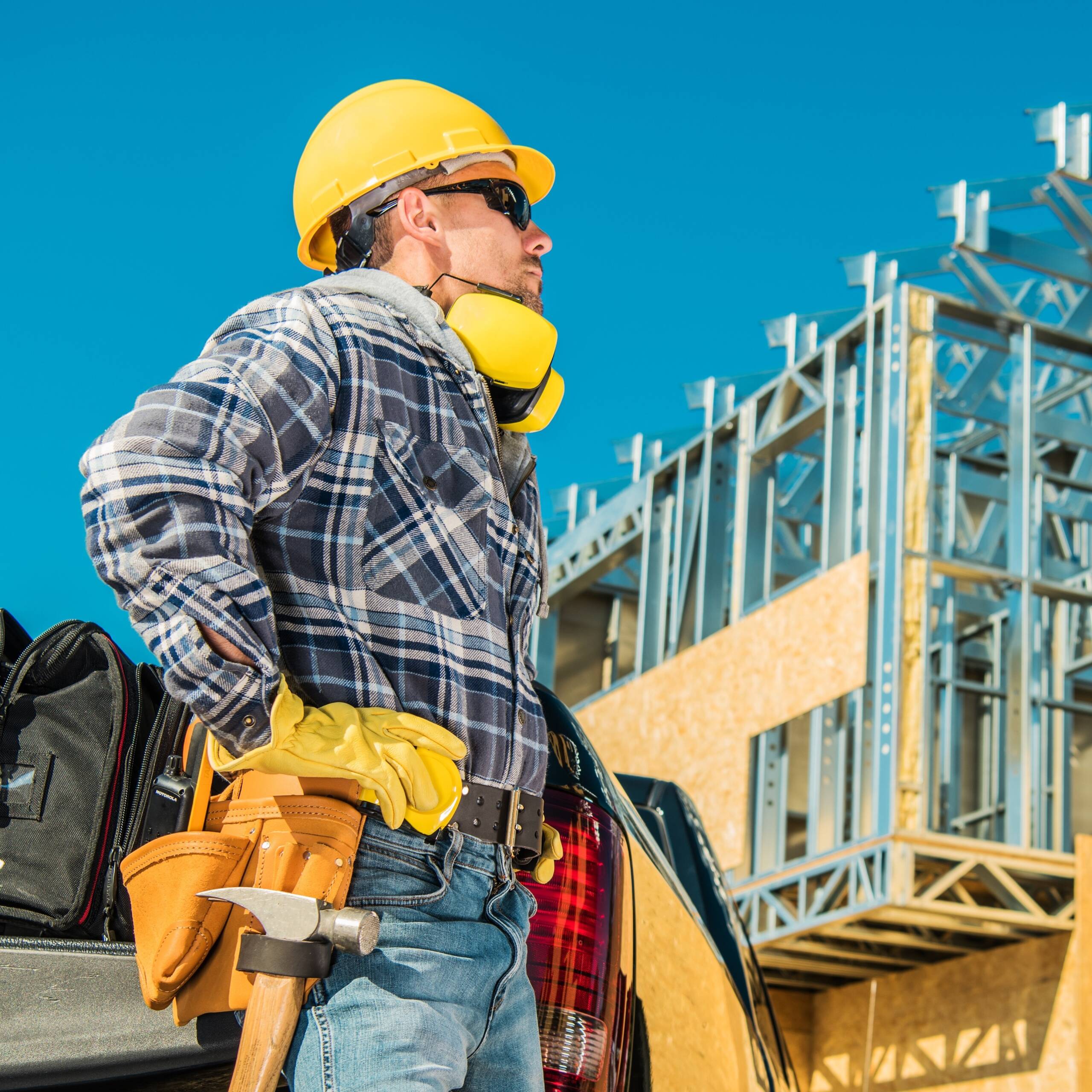 Skeleton Steel House Building. Construction Business Concept. Caucasian Worker in Yellow Hard Hat Taking Short Break During Working Hours.